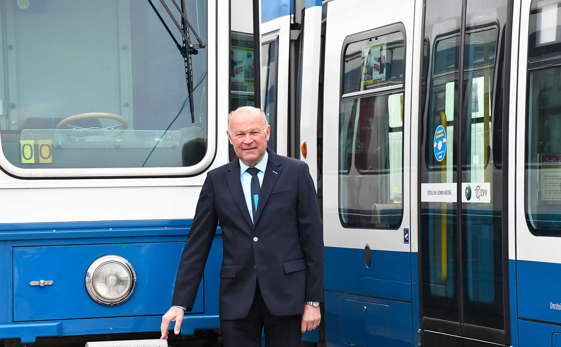 Portrait von Albert Lamprecht vor zwei Trams.